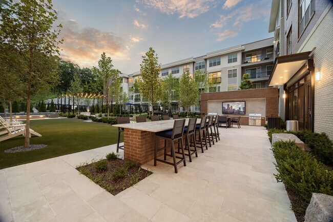 Resident courtyard featuring multiple grilling stations and outdoor dining areas