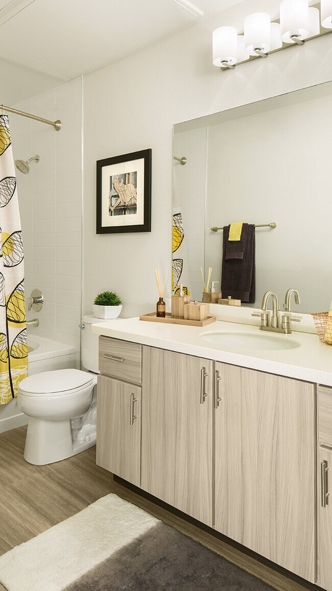 Baño del apartamento con espejo de tocador y bañera profunda.