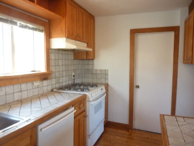 kitchen dishwasher stove and door to bathroom - 61 Christian St