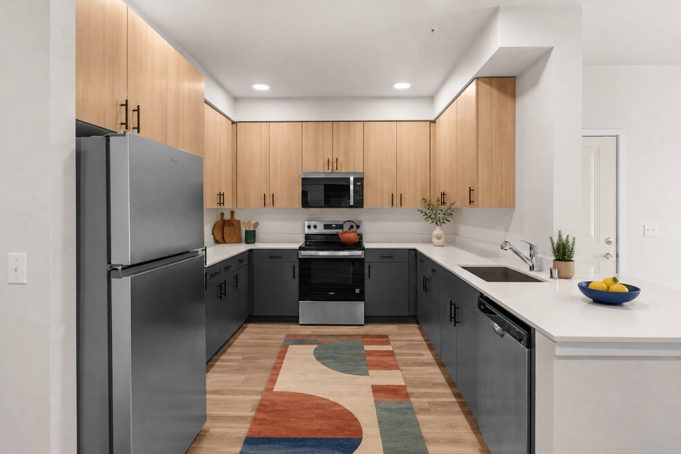 Staged kitchen showcasing the stainless steel appliance package, two-tone cabinetry, and ample workspace.