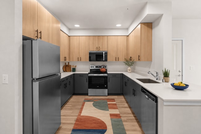 Staged kitchen showcasing the stainless steel appliance package, two-tone cabinetry, and ample workspace.