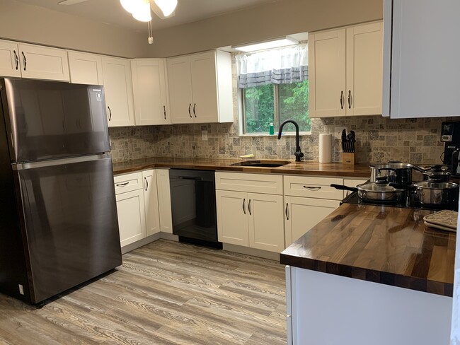 New Kitchen with New cabinets and black stainless appliances and European walnut butcher block tops - 5136 Old Lemay Ferry Rd Apartments