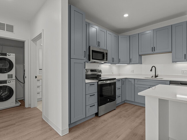 Modern kitchens with in-home laundry and premium finishes at The Elmwood Apartments.