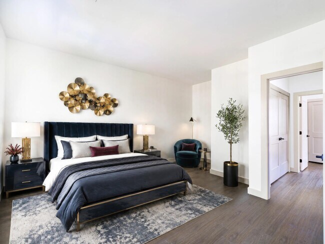 Spacious primary bedroom with warm flooring, refined finishes, and room for a sitting area that adds flexibility to everyday living.