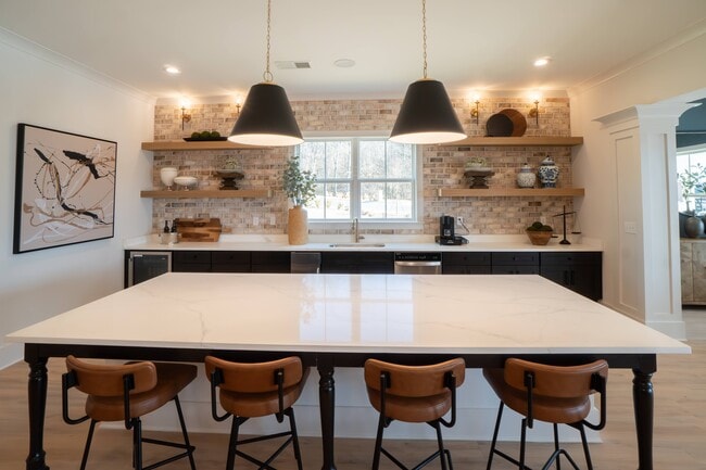 Kitchenette inside the clubhouse with bar seating, mini fridge and sink.
