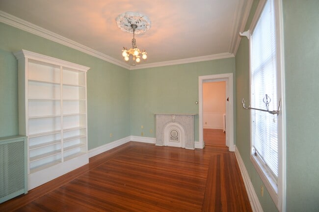 A stately chandelier and decorative fireplace add character to the living area - 226 Broadway Unit 2