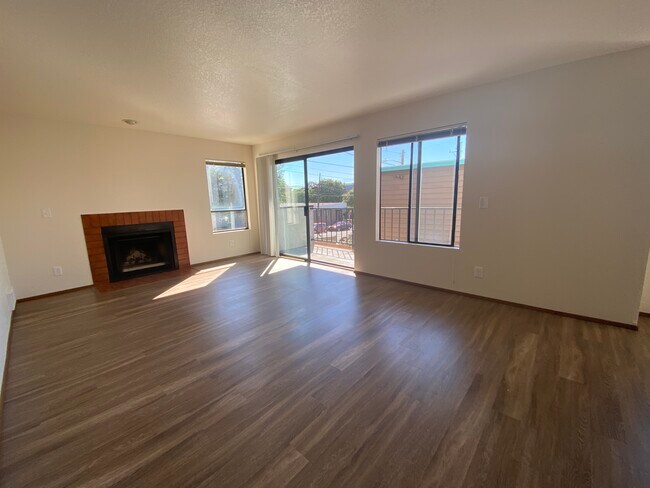 Open living room has wood burning fireplace - Mona Lisa Apartments