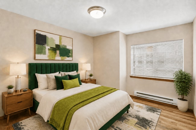 A comfortable bedroom with natural light and room for a complete furniture arrangement. - Tudor Village at the Mall Apartments