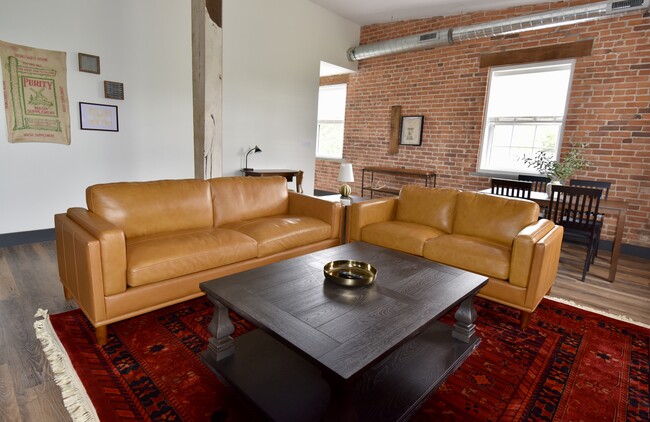 Furnished living room features leather couches, dining table and coffee tables - 101 W Broadway St Unit C