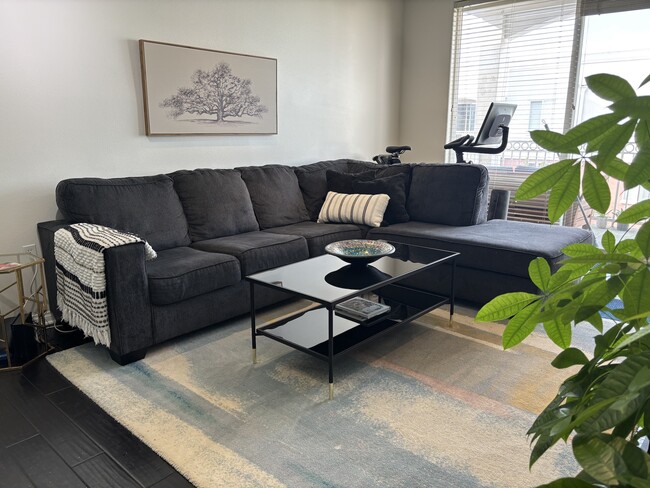 Spacious living room with sectional sofa, sleek coffee table, and contemporary decor - 3740 Santa Rosalia Dr Condo Unit 426