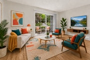 A bright and welcoming living room with vibrant décor, abundant natural light, and direct access to a relaxing private patio.