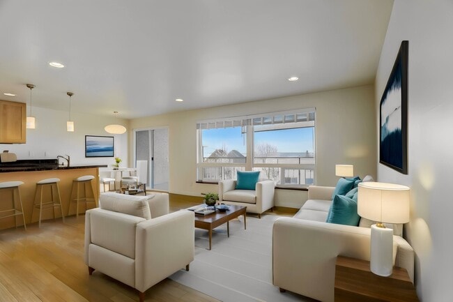 A spacious living room featuring comfortable sofas, a stylish coffee table, and a view of the kitchen, creating a seamless and inviting living space. - Alaska 45