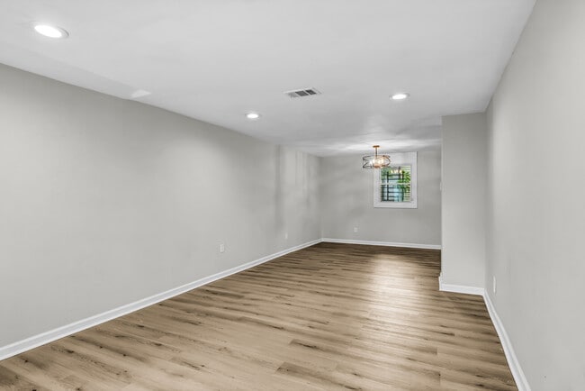 Open concept living room and kitchen eating area has brand new flooring