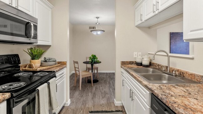 Chic kitchen with abundant cabinet space and wood-style flooring that seamlessly flows into the dining and living area. Perfect for hosting!