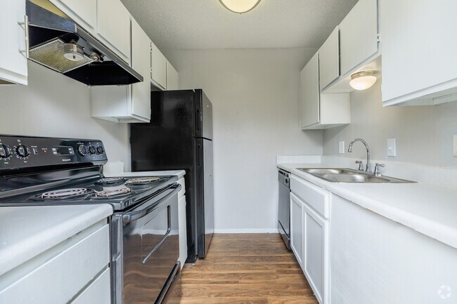 Discover a beautifully updated kitchen featuring bright cabinetry, sleek countertops, and modern black appliances. With ample storage and a functional layout, this space is designed for both style and efficiency. - Casa Del Sol Rental