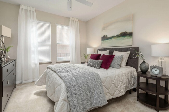 Spacious bedroom with plush carpeting, large windows, and modern finishes—comfortable apartment living in Charlotte.