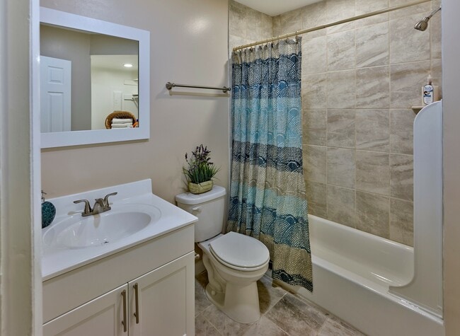 Enjoy a clean, modern bathroom at Haynes Run Apartments featuring neutral tile, sleek fixtures, and updated design elements. - Haynes Run