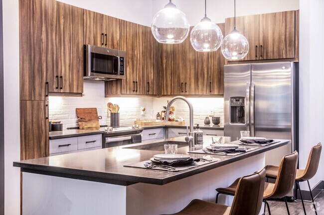 Our chef-inspired kitchens feature stainless steel appliances and side-by-side refrigerators. - Windsor Interlock Rental