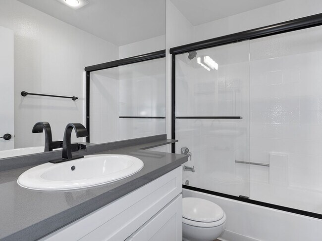 White bathroom with modern fixtures, shower, and tub.