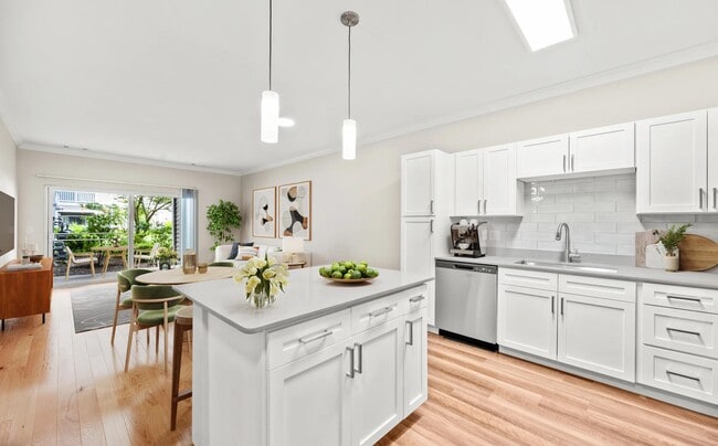 Open-concept kitchen with shaker-style cabinetry, a spacious prep island, and seamless flow into the dining and living areas for easy everyday living.