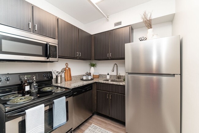 Kitchen with granite counters, modern cabinetry, and stainless appliances