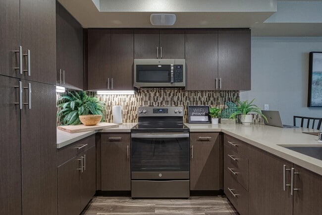 Cozy kitchen with dark cabinetry, tile backsplash, and an organized layout suited for everyday cooking.