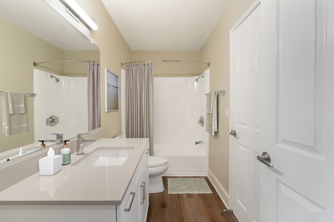 Renovated Package I bath with beige granite countertops, white cabinetry, and hard surface flooring