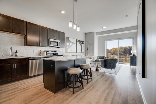 Enjoy the elegance of our kitchens with dark cabinetry and modern finishes. - Aspire at CityPlace Apartments