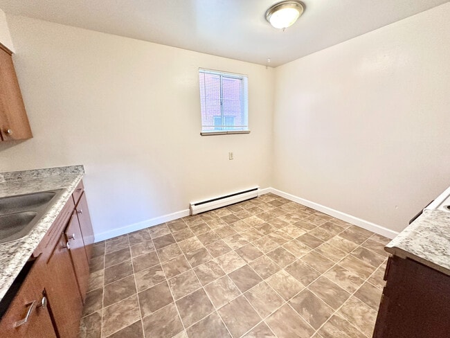 Bright and inviting kitchen with new granite countertops and tile flooring, perfect for cooking and entertaining. - 7250-7290 Newton Street