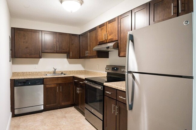 Classic kitchen style with rich cabinetry and neutral countertops, offering a warm, timeless aesthetic. - Stone Run East Rental