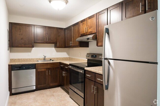Classic kitchen style with rich cabinetry and neutral countertops, offering a warm, timeless aesthetic. - Stone Run East Rental