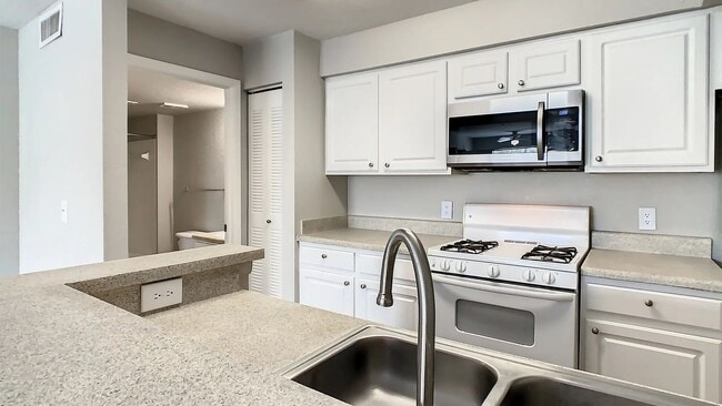 Our kitchens feature ample counter space and a breakfast bar. - Eden Pointe