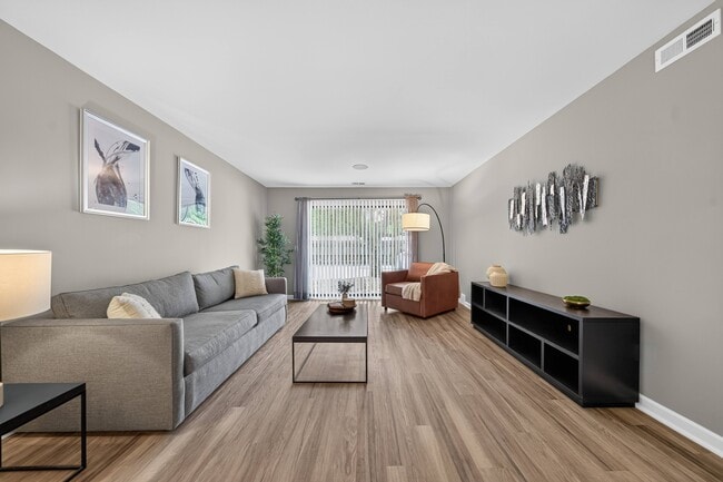 Spacious living room with Sliding Glass Door at Lakeside Village Apartments in Clinton Township, MI.