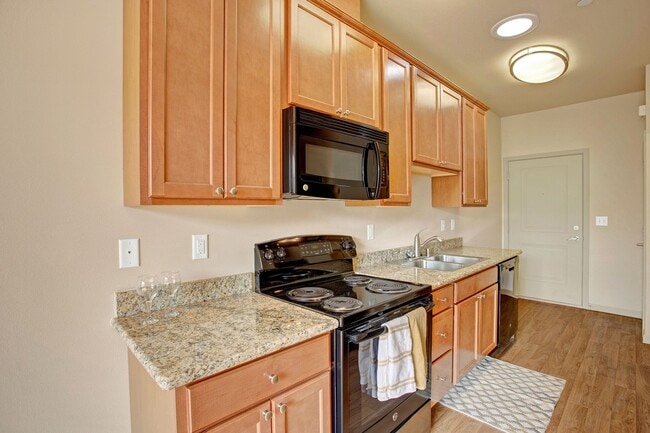 An open kitchen with a deep double sink, lots of cabinet storage, and plenty of counter space - Riverside 9