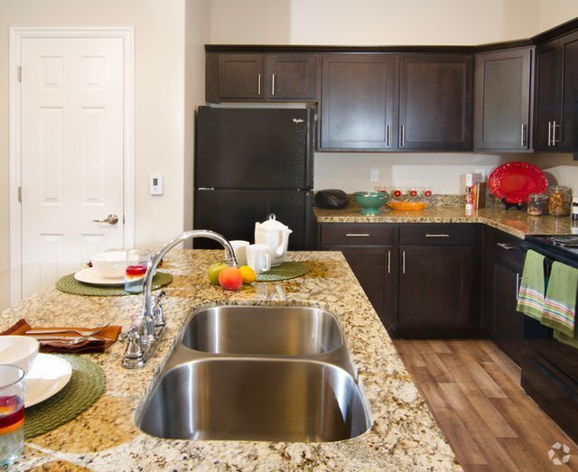 Modern Kitchen with Granite Countertops and Upgraded Black Appliances - Talavera at the Junction Apartments & Town...