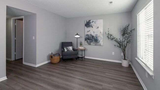 Esta acogedora sala de estar cuenta con una decoración moderna, cómodos asientos y abundante luz natural, lo que crea un espacio perfecto para la relajación y el ocio. - Emory Lakes Luxury Apartments