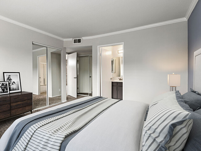 Carpeted bedroom with access to private bathroom.