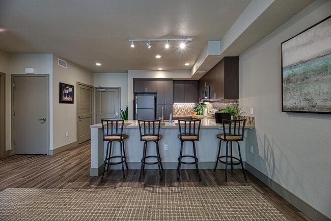 Spacious bar seating opens to an open-concept kitchen, creating an inviting spot for casual dining. - Vespaio