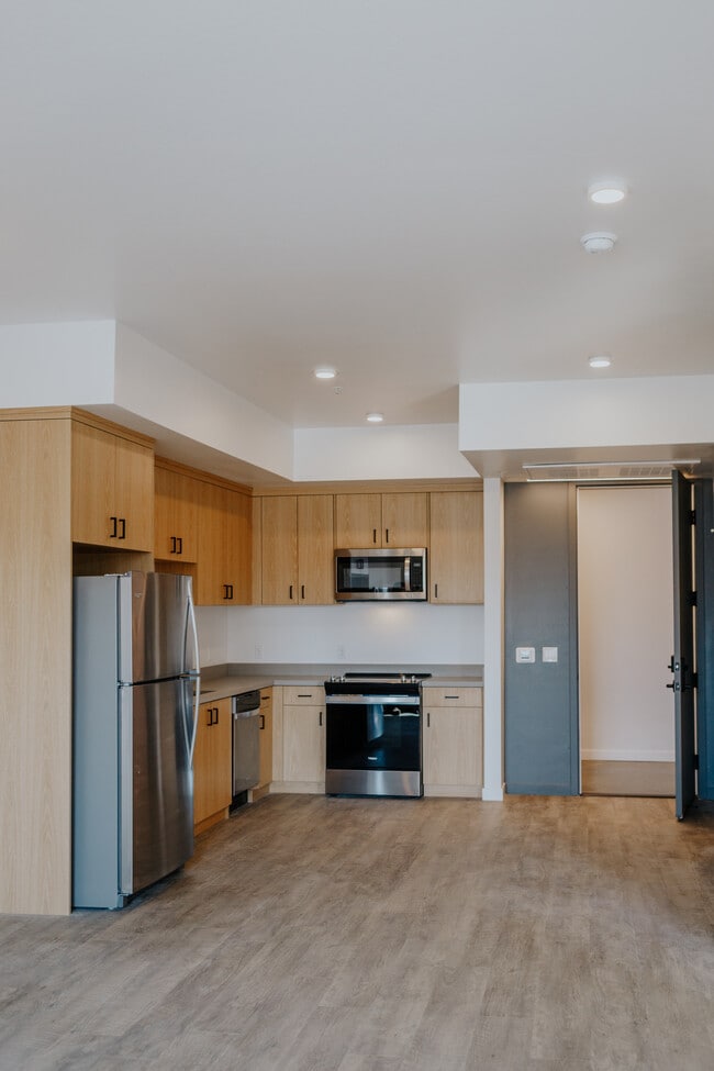 clean modern kitchen with custom cabinetry - The Cue Apartments