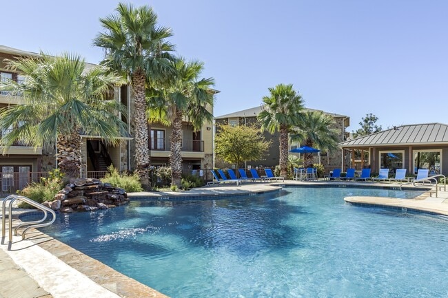 Resort inspired pool with lush palm trees and lounging - Azul Apartment Homes