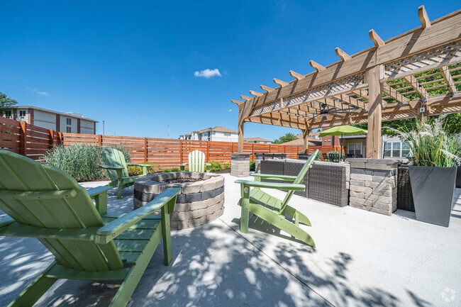 Espacio de salón al aire libre con pérgola y fogatas