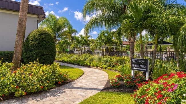 Stroll through the vibrant and lushly landscaped walkway leading to the leasing office. Surrounded by tropical plants and greenery, this inviting path sets the tone for a welcoming and serene community. - POSTE Winter Park