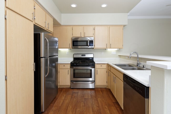 Classic Package II kitchen with stainless steel appliances, laminate countertops, oak cabinetry, and hard surface flooring