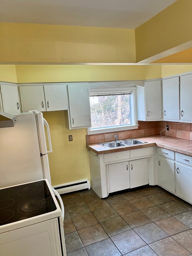 Cocina - vista desde la entrada del apartamento. La puerta principal del apartamento da a la cocina. - 114 Buell St Unidad 1