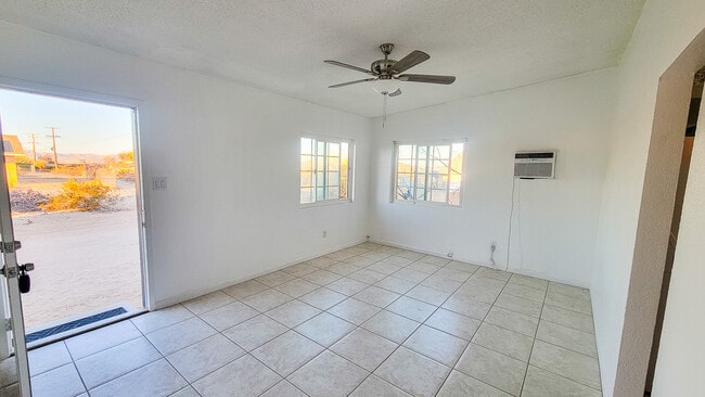 Living room with ceiling fan and natural light - 5527 Baileya Ave Unit A