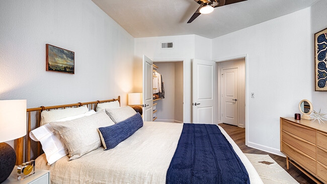 Spacious apartment bedroom with large closet and wood-style flooring. - Griffis South Bay