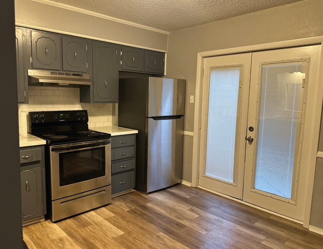 Kitchen w/Stainless Steel Appliances. French doors leading to backyard. - 8302 Woodview Dr E Unit 8302 Woodview Drive East