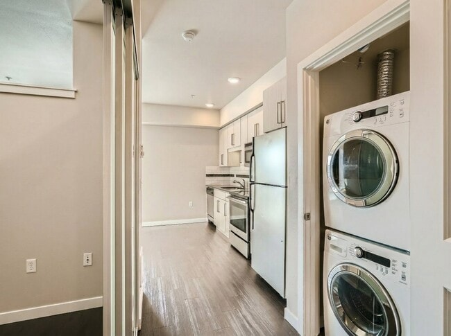 In-unit stacked washer and dryer located in a dedicated closet just off the kitchen at 306 Queen Anne in Seattle.
