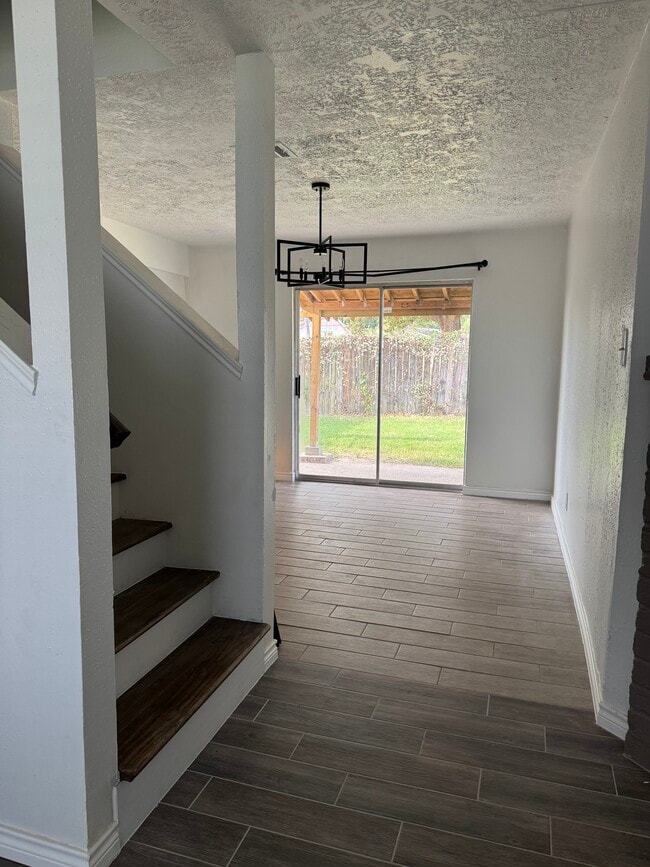 Open entryway highlighting continuous flooring, natural light, and access to upper levels.