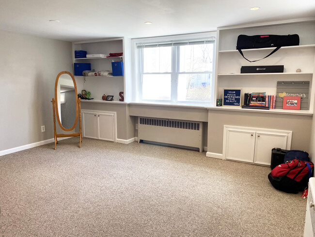 Den with ample sunlight and bookshelves - 110 Dobson St Apartments Unit LL